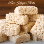 Classic Rice Krispie Treats made with marshmallows, butter, and Rice Krispies cereal, cut into neat squares on a white plate.