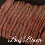 Beef bacon recipes with crispy strips served on a wooden plate alongside fresh herbs and breakfast sides.