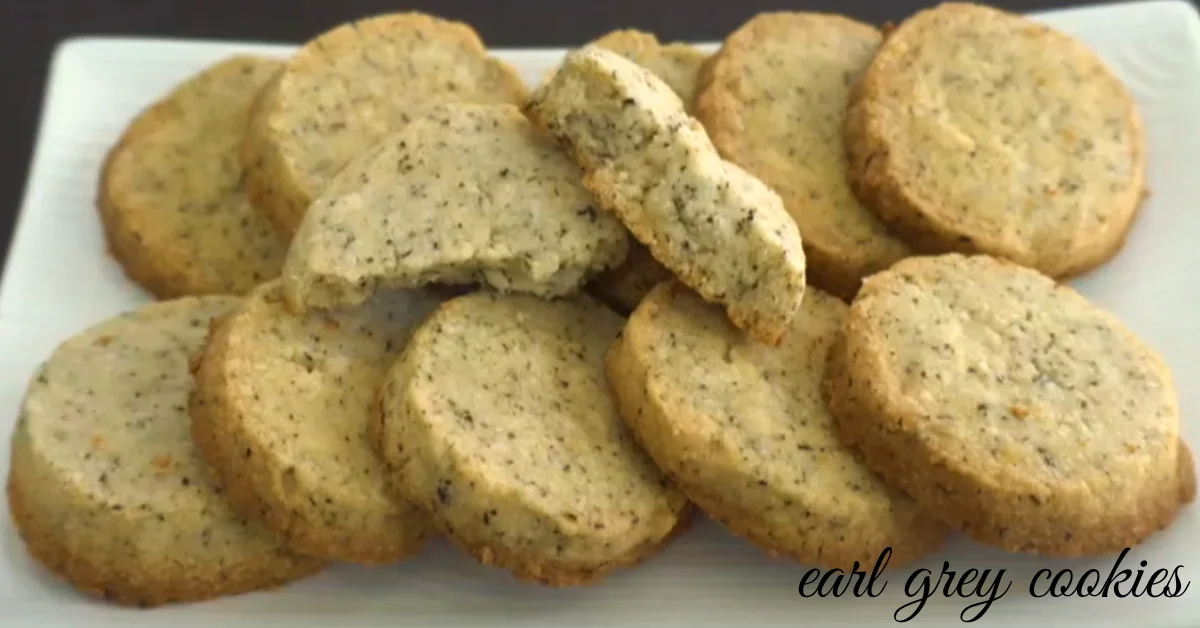 Freshly baked Earl Grey cookies on a white plate, infused with aromatic tea flavors and garnished with a touch of lemon zest.